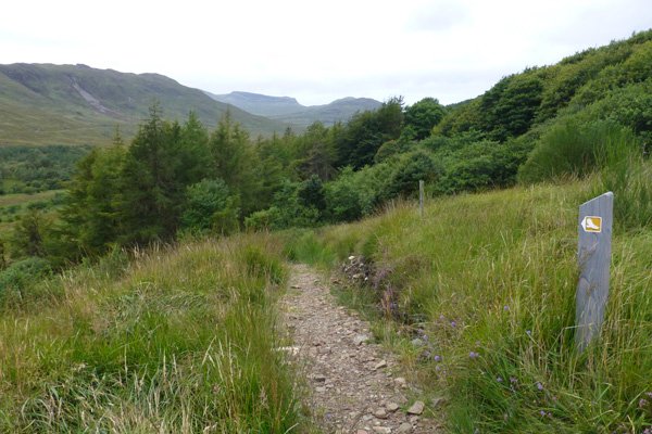 The path turns left for a steepish descent to the valley bottom