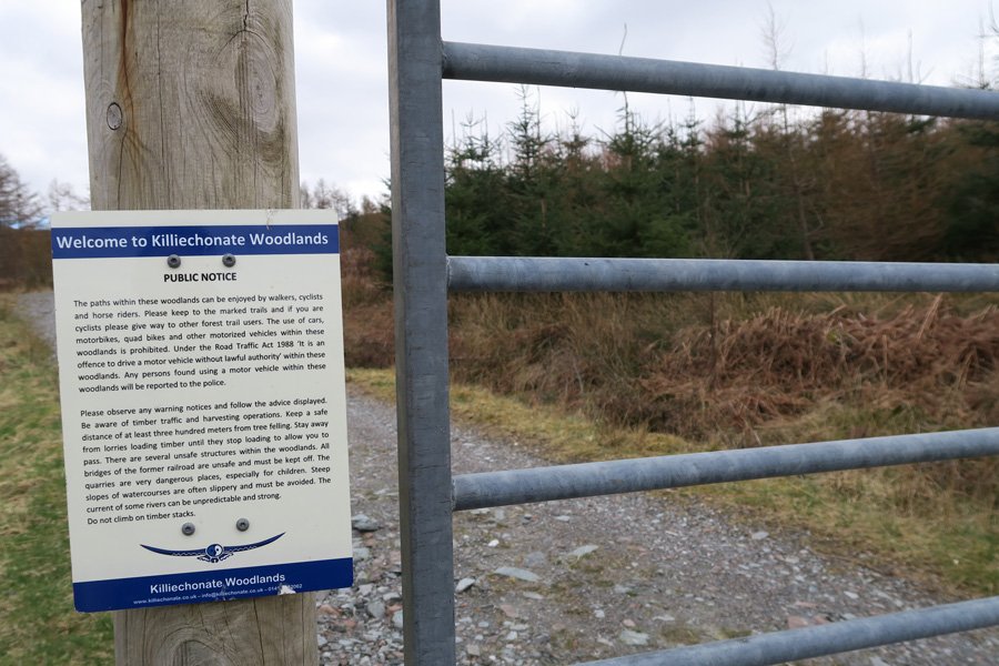 The track passes through a metal gate into Killiechonate Woodlands